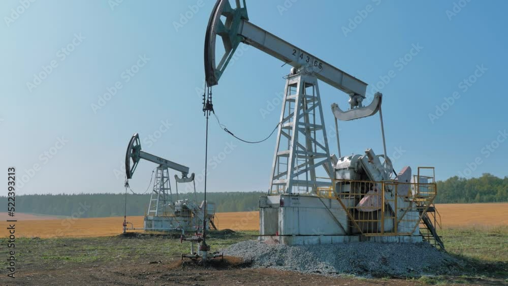 Pumping rigs extracting oil from an oil well in vast oil field. Oil Industry Equipment. Pumping rigs extracting oil from an oil well in vast oil field. Oil Industry Equipment.