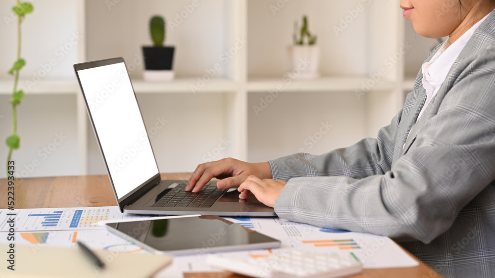 Side view female investor or economist working with digital tablet and financial document at office Side view female investor or economist working with digital tablet and financial document at office