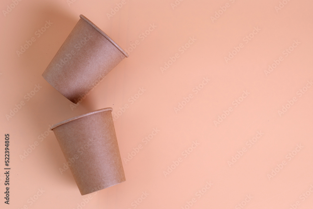 Disposable paper coffee cups on pastel background. Eco-friendly hot drink containers top view. Disposable paper coffee cups on pastel background. Eco-friendly hot drink containers top view.