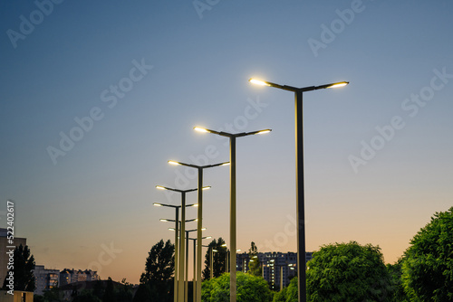 A modern street LED lighting pole. Urban electro-energy technologies. A row of street lights against the night sky photo