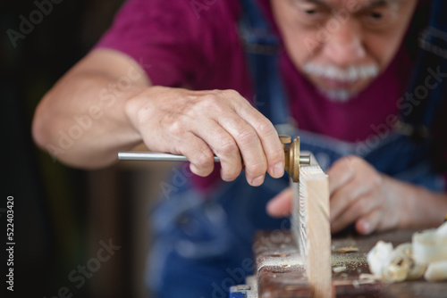  A man works in a carpentry shop. Carpenter working on woodworking machines in carpentry shop.