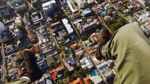 POV of a paraglider flying over a suburb. His leg is dangling in shot. photo