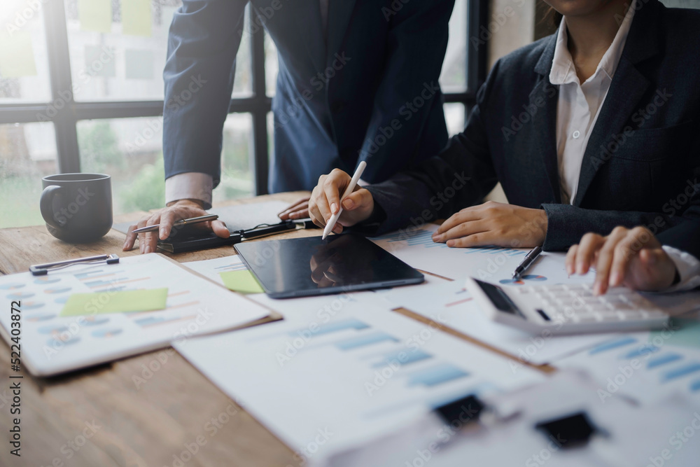 Business people pointing to a graph to analyze market data Net profit balance sheet to plan new marketing strategies to extend existing products. Business people pointing to a graph to analyze market data Net profit balance sheet to plan new marketing strategies to extend existing products.