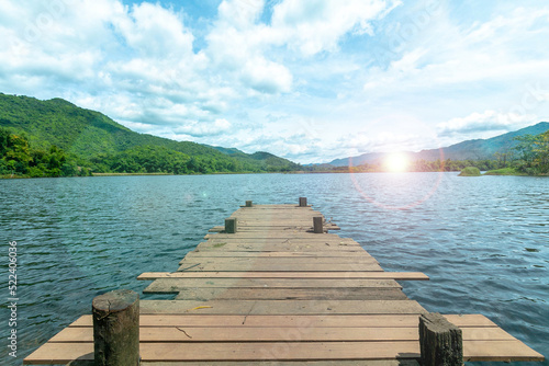 Fototapeta Naklejka Na Ścianę i Meble -   Wooden bridge  with the lake mountain and sky landscape. Wood floor with lake mountain and sky of nature park background and summer season