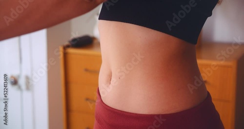 Fit young woman stretching flat stomach inside apartment. Fitness concept