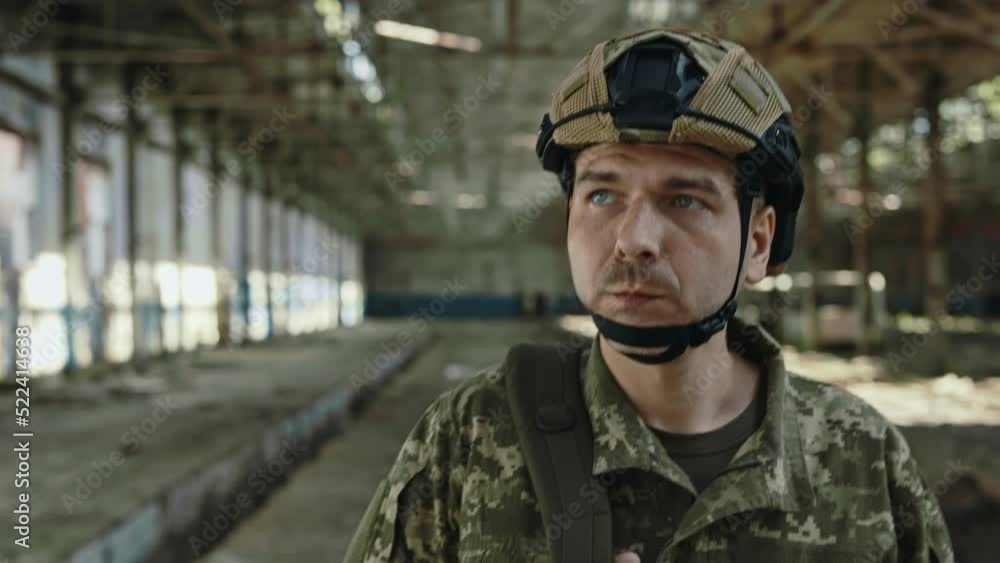 Brave caucasian man in safety helmet and military uniform looking around while walking on destroyed industrial manufacture. Qualified officer on secret military mission. Brave caucasian man in safety helmet and military uniform looking around while walking on destroyed industrial manufacture. Qualified officer on secret military mission.