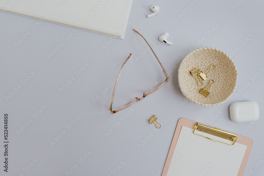Glasses, clipboard, headphones, gold accessories on white background with blank mockup copy space. Flat lay, top view minimalist home office desk workspace template Glasses, clipboard, headphones, gold accessories on white background with blank mockup copy space. Flat lay, top view minimalist home office desk workspace template