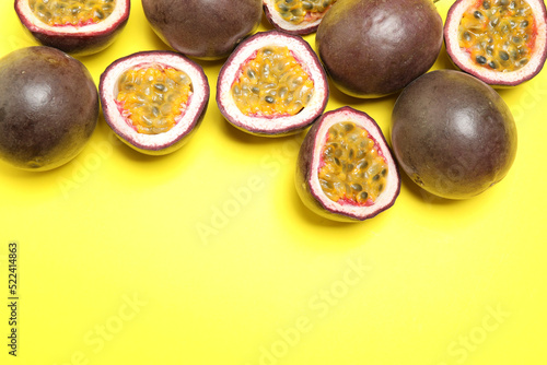 Fresh ripe passion fruits (maracuyas) on yellow background, flat lay. Space for text
