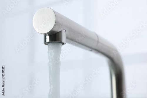Stream of water flowing from tap on white background, closeup