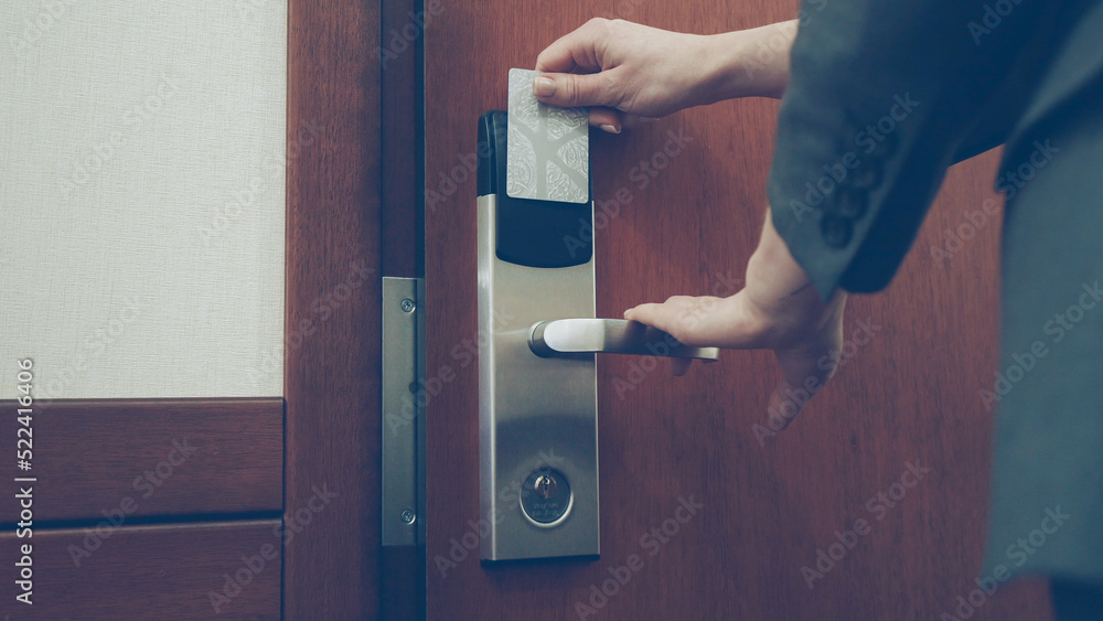 Close-up of businesswoman in suit open hotel room door using contactless key card and entering the room. Travel, business and people concept Close-up of businesswoman in suit open hotel room door using contactless key card and entering the room. Travel, business and people concept