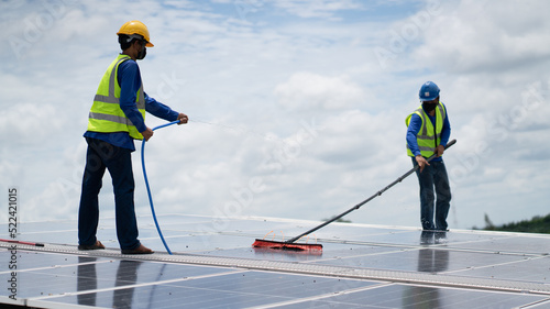 Construction workers clean solar panels for energy.Renewable Energy Battery Clean Mountain Climber Activities Work Uniforms.Managers discuss electric power ecology, human, renewable energy. 