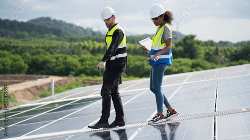 Engineers, males inspecting solar panels on the roof, inspecting safety and cleaning services. Construction industry, construction personnel 