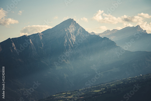An evening in the swiss alps with the Piz Beverin mountain and the village of Urmein in the Domleschg Valley. photo