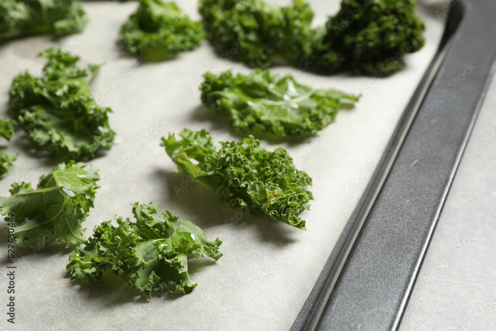 Raw cabbage leaves on baking sheet, closeup. Preparing kale chips Raw cabbage leaves on baking sheet, closeup. Preparing kale chips
