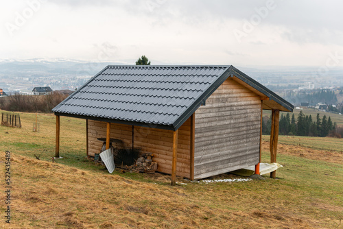A beautiful panoramic landscape of mountains in grey rainy weather in Europe. Wooden summer house  cottage  beautiful nature. Breathtaking view. 