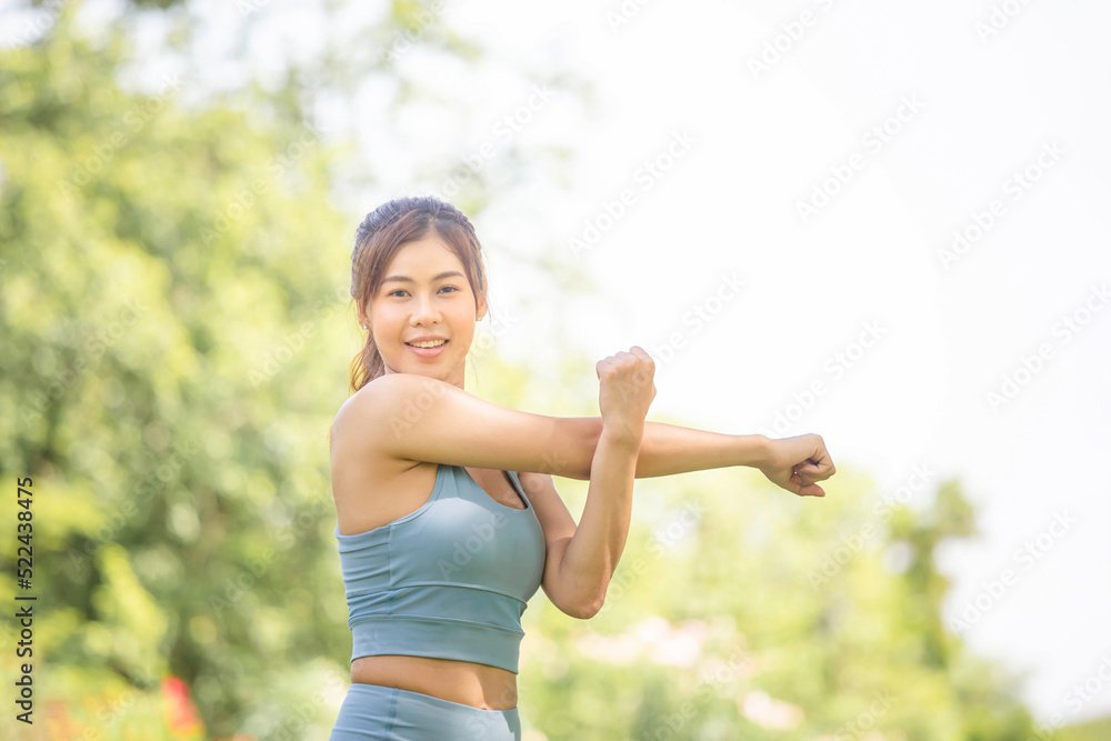 Fitness woman stretching muscles before sport activity, Woman gym in park morning exercise, Young sportswoman doing workout stretches hand and preparing to run