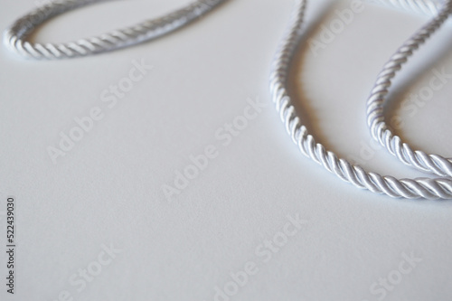 White rope cord silky silver textile tie curved lasso line background 