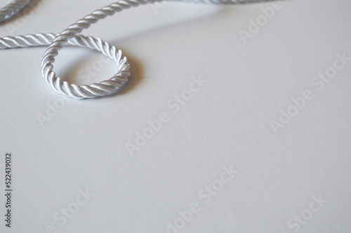 White rope cord silky silver textile tie curved lasso line background 