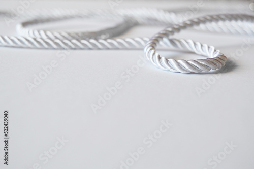 White rope cord silky silver textile tie curved lasso line background 