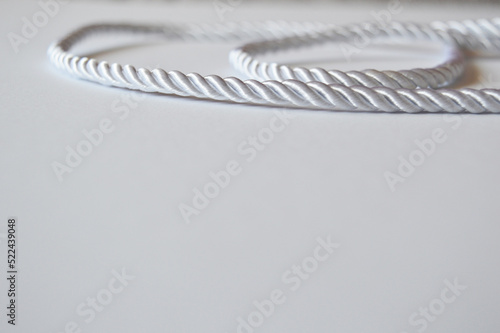 White rope cord silky silver textile tie curved lasso line background 