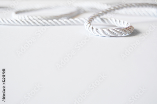 White rope cord silky silver textile tie curved lasso line background 