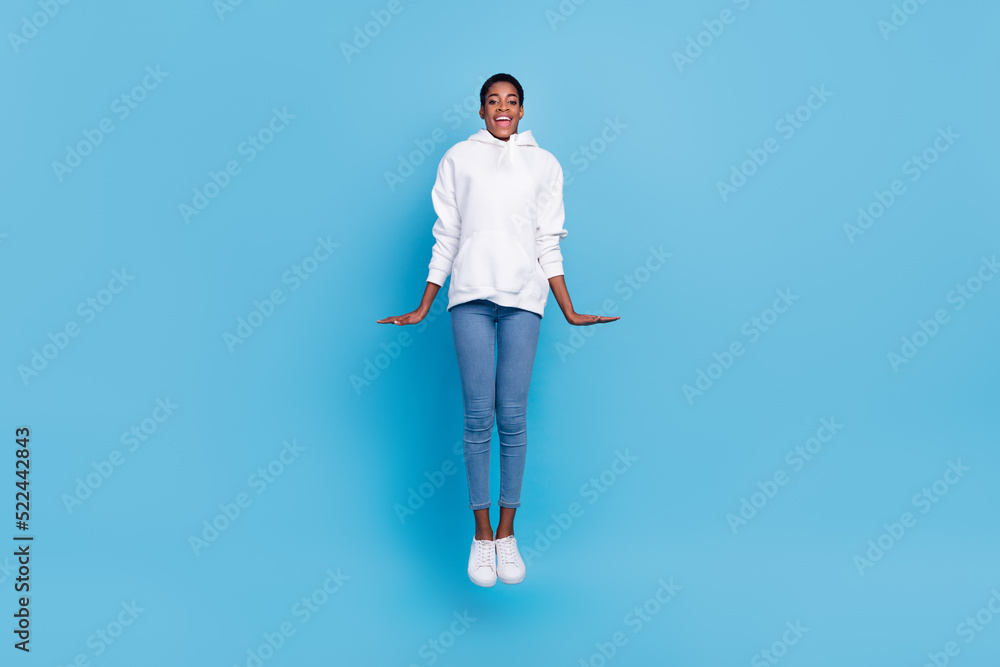 Photo of attractive charming trans girl wear white sweatshirt jumping high isolated blue color background
