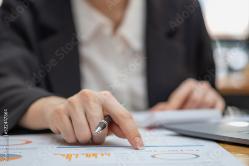 Marketing, Financial, Accounting, Planning, Business women analyze company results and profits with graph statistics. Use a laptop computer and a calculator to calculate the company's balance.