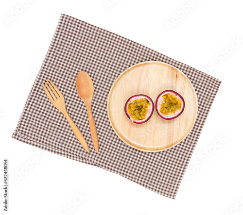 Top view of passion fruit on wood plate with spoon fork and chess pattern cloth photo