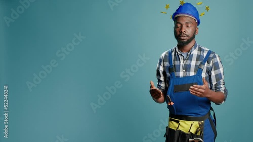 African american construction worker being dizzy and lightheaded, circle of stars above head concept. Engineer with hardhat, dizziness cartoonish style. 3d render animation. photo