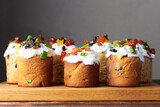 Several Kulich. Traditional easter cakes, bread with meringue and colorful sprinkles and candied fruit on wooden background