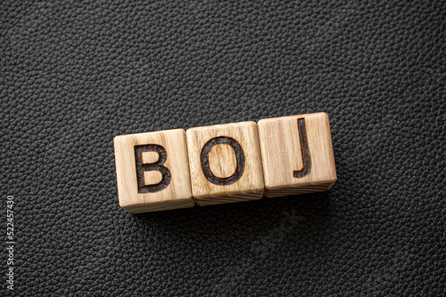 BOJ - acronym from wooden blocks with letters, Japanese central bank, Bank of Japan BOJ concept,  top view on grey background photo