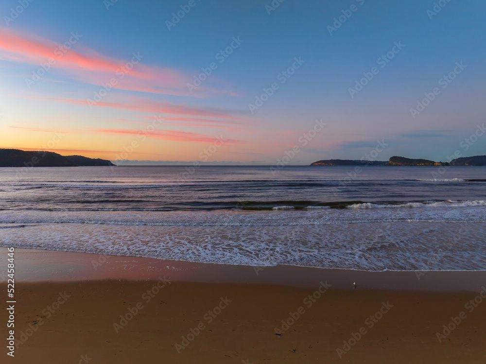 Gentle sunrise seascape with light scattered high cloud