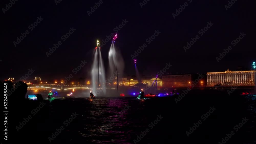 A lot of flyboarders and brightly dressed up jet skiers perform their show at a holiday in the center of St. Petersburg at night, water activities A lot of flyboarders and brightly dressed up jet skiers perform their show at a holiday in the center of St. Petersburg at night, water activities