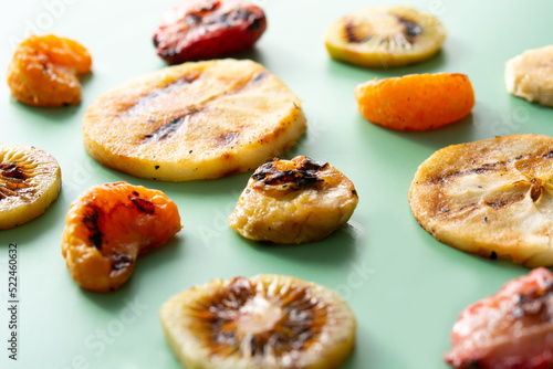 Grilled fruit on green background