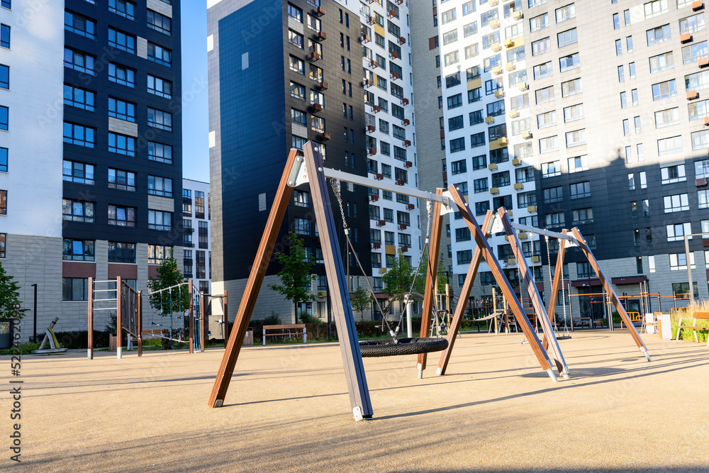 Empty metal chain swings on the empty kids children playground courtyard of the residential district Empty metal chain swings on the empty kids children playground courtyard of the residential district