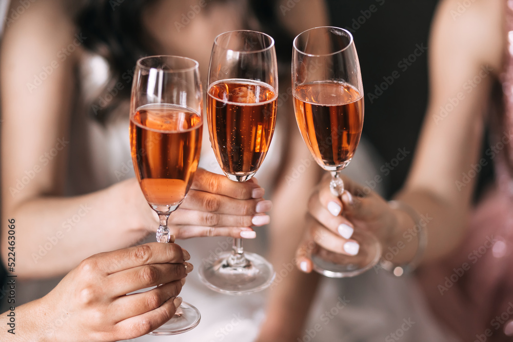 Bride with best bridesmaids are holding glasses and drinking champagne in hotel. Bride with best bridesmaids are holding glasses and drinking champagne in hotel.