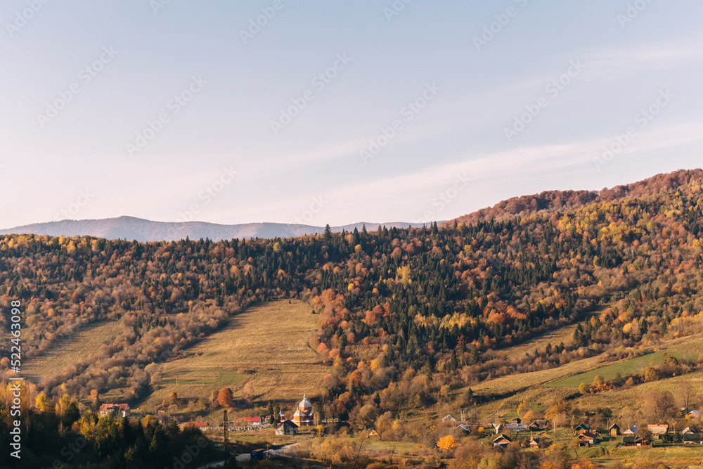 Beautiful autumn afternoon in mountains. trees on the edge of a hill in fall colors. wonderful countryside on a sunny weather in evening