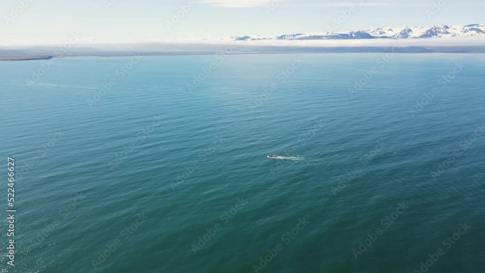 Aerial shot of a tourist boat which is going to see whales, located in Iceland, Húsavík. Top shot with a cinematic drone Aerial shot of a tourist boat which is going to see whales, located in Iceland, Húsavík. Top shot with a cinematic drone