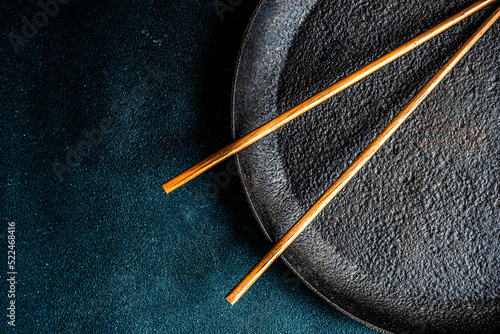 Overhead view of a pair of chopsticks on a metal plate