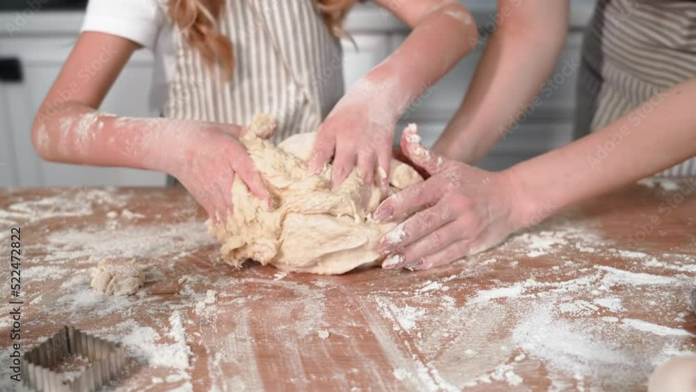 cooking together with parent, caring mother with her beloved female child preparing dough for baking at table in kitchen, close-up cooking together with parent, caring mother with her beloved female child preparing dough for baking at table in kitchen, close-up