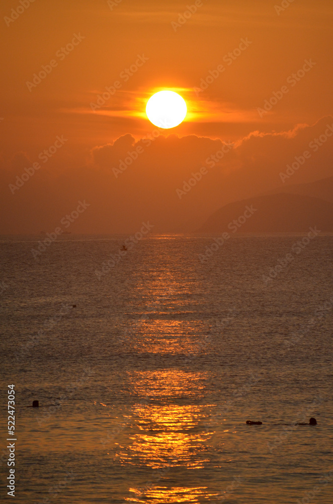 Morning sunrise over the calm sea in red - yellow colors. Vacation near the sea, travelling concept.