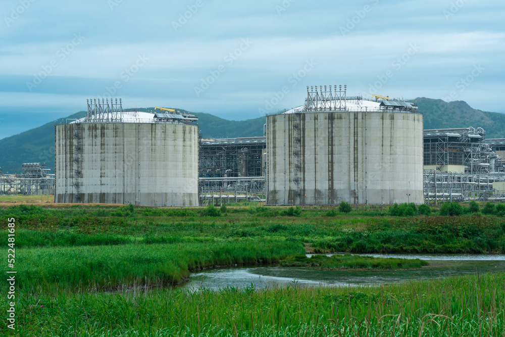 Fototapeta premium plant for the production of liquefied natural gas in a natural area against the backdrop of mountains