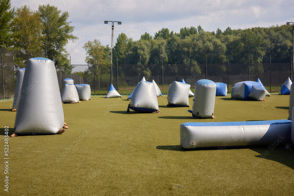 Paintball shooting range. Paintball territory in the forest. Iron barrels in the foreground with