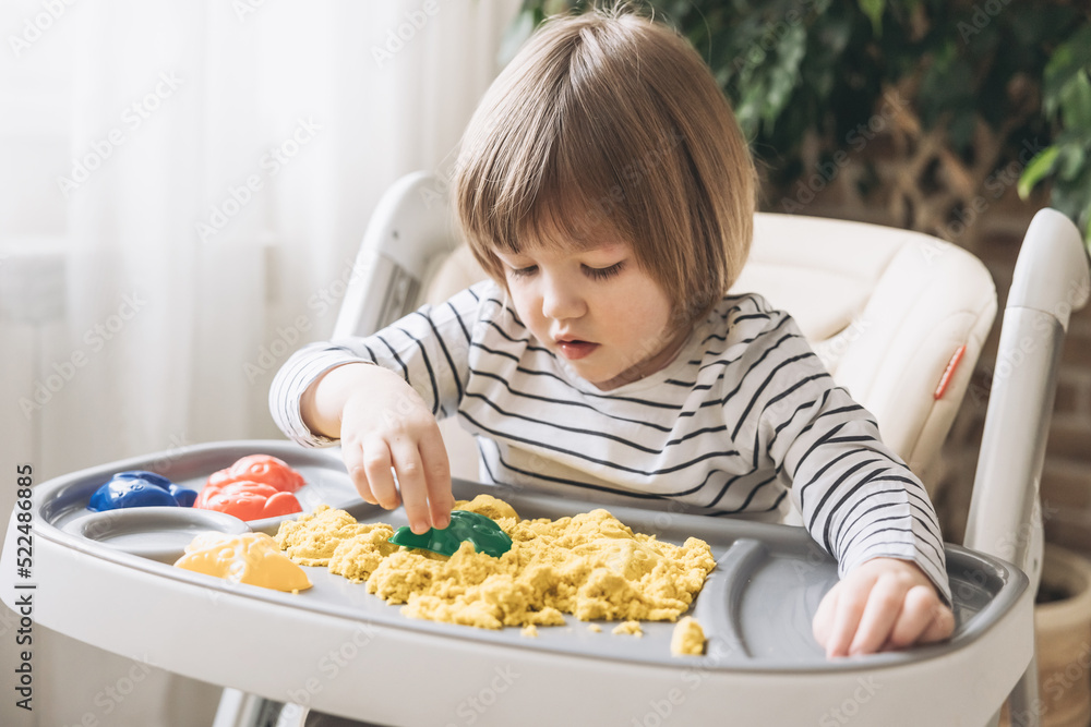 Cute little boy playing with kinetic sand. Development of fine motor skills. Early sensory education. Activities Montessori. Sensory plays at home. Cute little boy playing with kinetic sand. Development of fine motor skills. Early sensory education. Activities Montessori. Sensory plays at home.