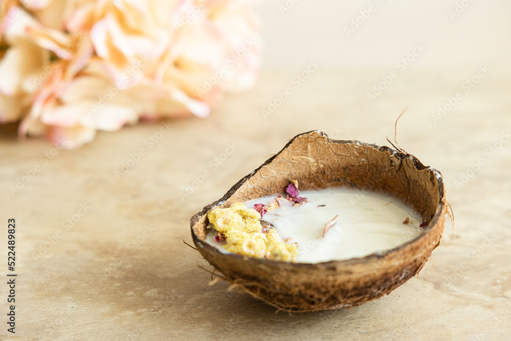 Handmade candle from soy and coconut wax in glass with wooden wick and dry flowers isolated on pastel beige background. Flat lay, top view, copy space Handmade candle from soy and coconut wax in glass with wooden wick and dry flowers isolated on pastel beige background. Flat lay, top view, copy space