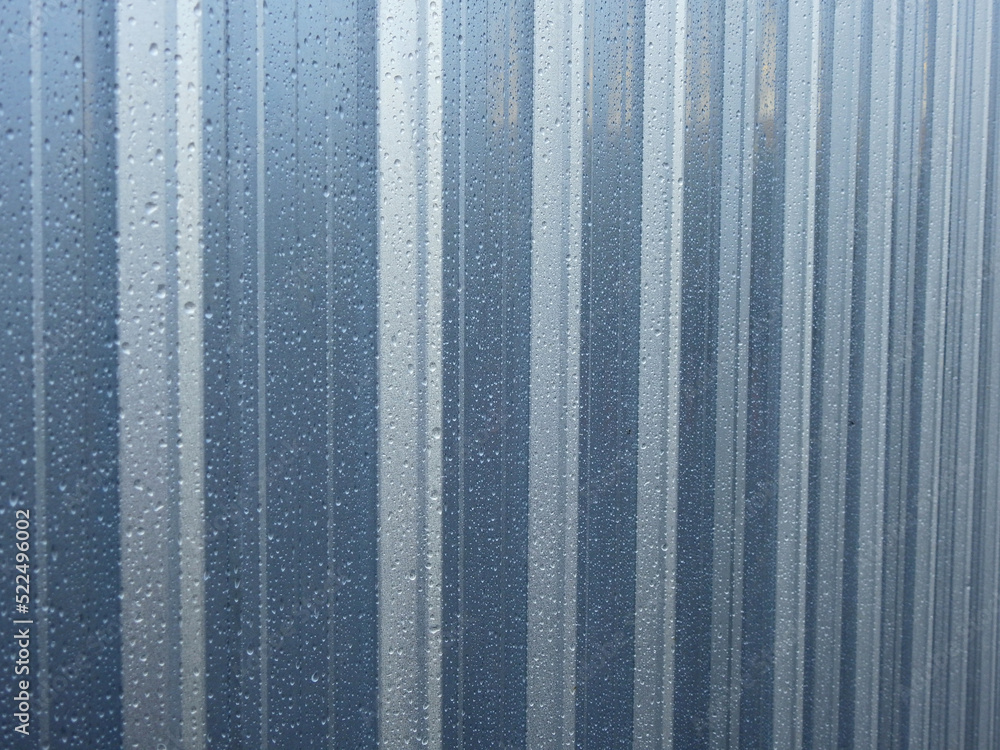 raindrops on silver metal sheet of fence after rain raindrops on silver metal sheet of fence after rain