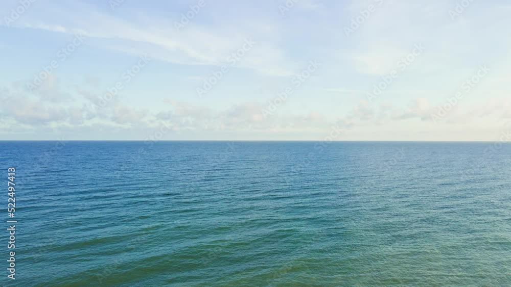 Top view of calm sea surface with waves and splashes, Beautiful ocean landscape with turquise water and cloudy sky Top view of calm sea surface with waves and splashes, Beautiful ocean landscape with turquise water and cloudy sky