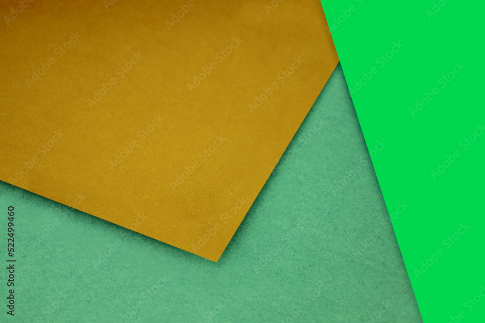 Plain and Textured pastel yellow green papers randomly laying to form M like pattern and triangle for creative cover design idea Plain and Textured pastel yellow green papers randomly laying to form M like pattern and triangle for creative cover design idea