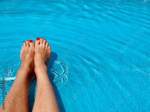 Female feet in the pool. Copy space