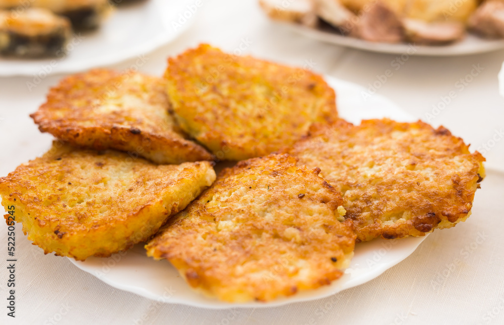 Fried grated potato pancakes with sour cream on white plate Fried grated potato pancakes with sour cream on white plate